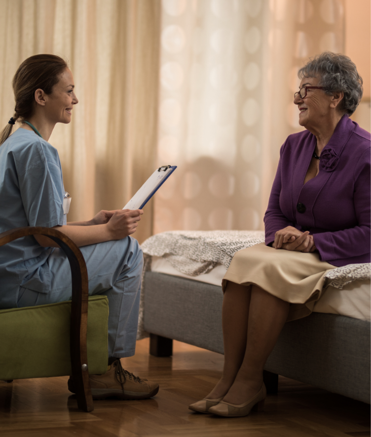 Female nurse talking with older woman in hospital setting