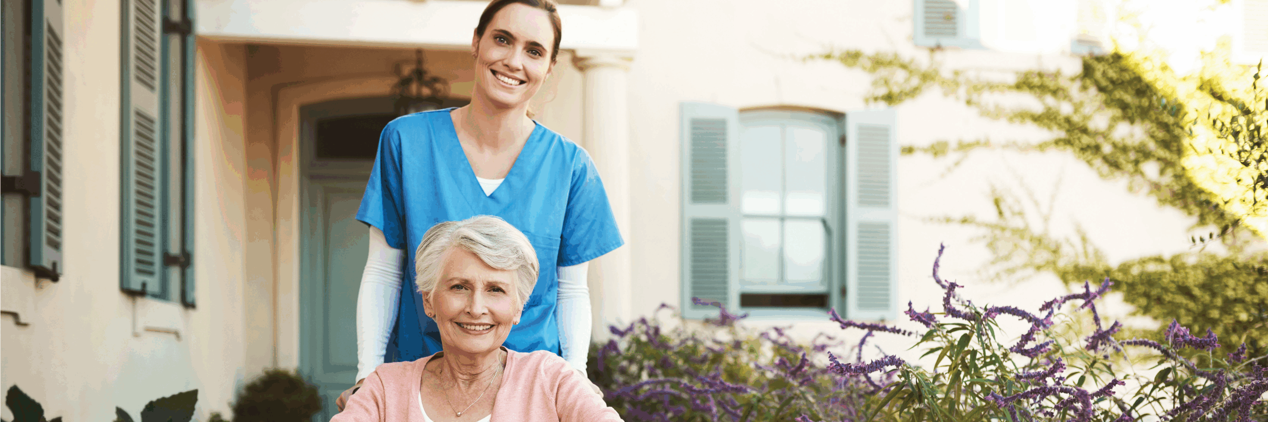 Home Health nurse outside of a patients home smiling with patient who is sitting in a wheelchair